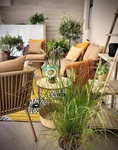 a living room with couches and potted plants at Appartamento in Villa in Ginosa Marina