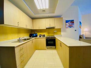 a kitchen with a sink and a stove at Clarence Apartment in Ras al Khaimah