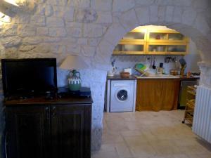 a kitchen with a stone wall and a washer and dryer at Villa Trullo Panorama in Locorotondo