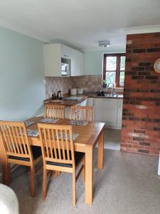 a kitchen with a wooden dining table and chairs at Gatekeeper Cottage in Norwich