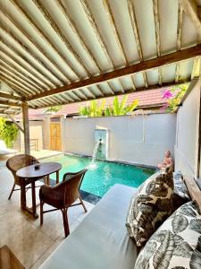 a swimming pool in the middle of a patio with a table at GiliZen Resort - Private Pool Villas in Gili Islands