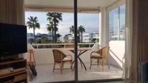 ein Wohnzimmer mit einem Balkon mit einem Tisch und Stühlen in der Unterkunft Apartment with amazing seeview in Miraflores Monte B in La Cala de Mijas