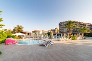 シダにあるSeamelia Beach Resort Hotel & SPAのリゾート内のプール(椅子、パラソル付)