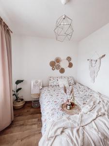 a bedroom with a bed with a table on it at Koralik - BOHO Apartamenty z BALIĄ w CENIE! Kluszkowce - 1 km od Velo Czorsztyn i CzorsztynSKI in Kluszkowce