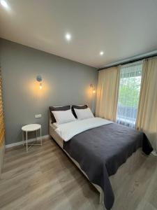 a bedroom with a large bed and a table at Evergreen Apart in Almaty