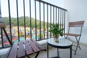 balcón con banco, mesa y ventana en *Ha Long Homestay @ Sunrise Apartment- 4 BR en Ha Long