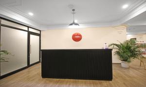 an office with a black reception desk and a clock on the wall at Treebo Trend Grand Legacy Shahenshah in Dehradun