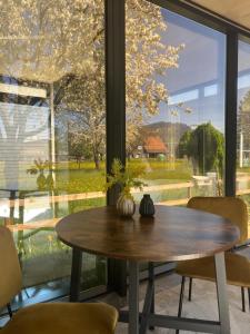 une table et des chaises devant une grande fenêtre dans l'établissement Natur Pur & Erlebnisurlaub im Spiegelhaus ÖÖD, à Lauterach