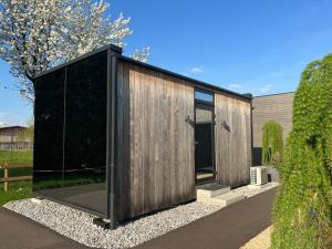 uma casa de madeira com um exterior negro em Natur Pur & Erlebnisurlaub im Spiegelhaus ÖÖD em Lauterach