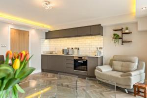 Una cocina con un sofá y una silla en una habitación. en Pleasant View - Direct Beach Access, Sea Views and Parking, en Saundersfoot 10 fotos más