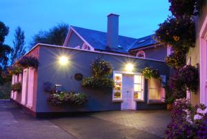 uma casa com flores ao lado dela em Fanad House em Kilkenny