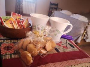 a table with two cups and a basket of bread at La mansarda del Sacro Bosco in Bomarzo