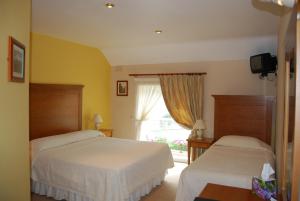 a hotel room with two beds and a window at Fanad House in Kilkenny