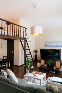 salon z kanapą i telewizorem w obiekcie Honey Apartment - LoftAffair w Krakowie