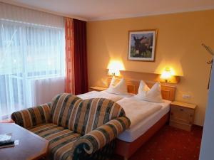 a hotel room with a bed and a couch at Gasthofladen Schneeweiss in Attersee am Attersee +32 photos