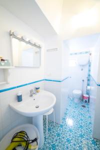 ein blau-weißes Badezimmer mit Waschbecken und Toilette in der Unterkunft MonoBlue in Procida