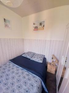 a small bedroom with a bed with a blue comforter at Appartement 4 pers au coeur de Soulac-sur-mer in Soulac-sur-Mer