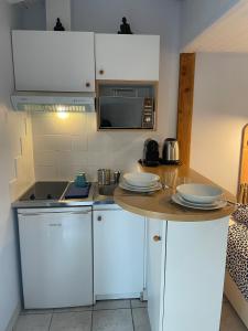 a kitchen with white cabinets and a wooden counter top at Le Petit Havre in Lacanau-Océan