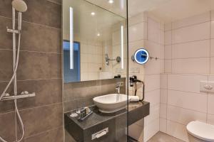 ein Bad mit einem Waschbecken und einer Dusche in der Unterkunft Holiday Inn - Villingen - Schwenningen, an IHG Hotel in Villingen-Schwenningen