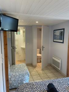 a bedroom with two beds and a flat screen tv at Le Petit Havre in Lacanau-Océan