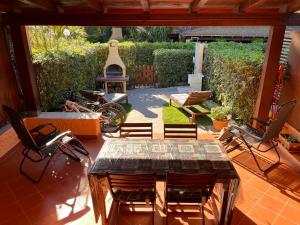 a patio with a table and chairs and a grill at Accogliente casetta a Calaverde, Pula. in Pula