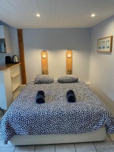 a bedroom with a large bed with shoes on it at Le Petit Havre in Lacanau-Océan