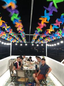 un grupo de personas sentadas en una mesa con cometas de colores en Thảo Nguyên Hotel en Vung Tau