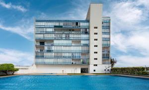 un edificio alto con una piscina frente a él en Apartamento Edificio la Masía, en Roses