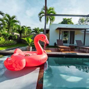 邦勞的住宿－Halamanan Residences，游泳池里充气的粉红色天鹅