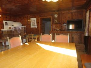 een eetkamer met een houten tafel en een televisie bij Apartment Apart 14 by Interhome in Obergand