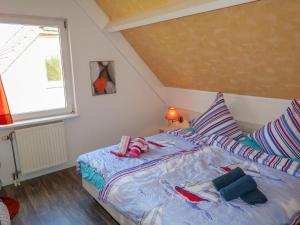 a bedroom with a bed with two pillows and a window at Holiday Home Tossens-3 by Interhome in Butjadingen OT Tossens