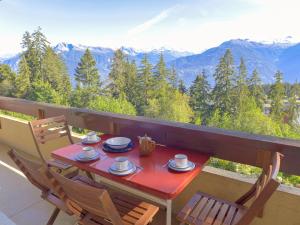 einen Tisch und Stühle auf einem Balkon mit Bergblick in der Unterkunft Apartment Imperia by Interhome in Crans-Montana