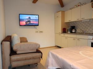 Sala de estar con silla y TV en la pared en Apartment Miriam - SIX200 by Interhome, en Spiss