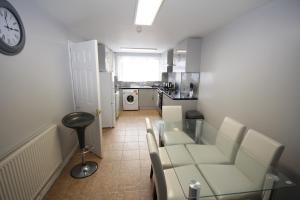 a living room with a table and chairs and a clock at The Greatfields Drive in Hillingdon