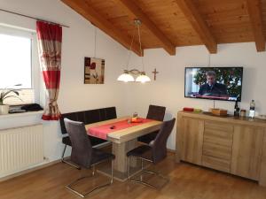 a dining room with a table and a tv at Apartment Piz Munschuns - SIX100 by Interhome in Spiss