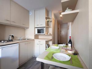 a small kitchen with a table with a bottle of wine at Apartment Vanoise 167 by Interhome in Val Thorens +28 photos
