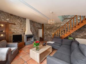 ein Wohnzimmer mit einem Sofa und einem Kamin in der Unterkunft Holiday Home La Bastide by Interhome in Thy-le-Bauduin