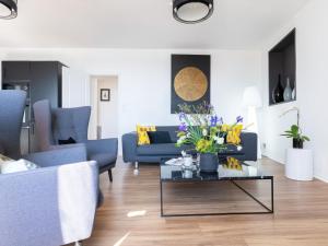 uma sala de estar com um sofá e uma mesa com flores em Apartment Ô de Mer - ETL300 by Interhome em Étel