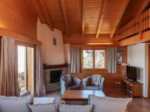 a living room with chairs and a table and a tv at Chalet Lara by Interhome in Plan Fey