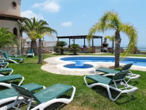 a group of lawn chairs next to a swimming pool at Holiday Home Villa Pepe by Interhome in Motril