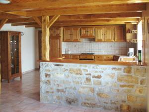 Telgruc-sur-MerにあるHoliday Home Trez Bellec - TGM101 by Interhomeの石壁のキッチン(木製キャビネット付)