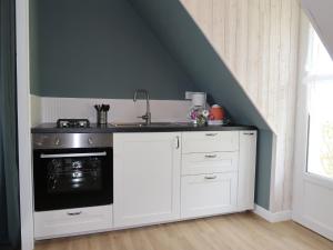 a kitchen with a sink and a stove at Holiday Home Les Hortensias - PZV107 by Interhome in Plozévet