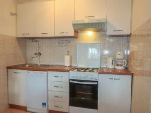a kitchen with white cabinets and a stove top oven at Holiday Home Mateja - KRK228 by Interhome in Kornić