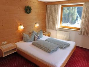 a room with a bed with three pillows and a window at Apartment Alpenhof-1 by Interhome in Sinsen