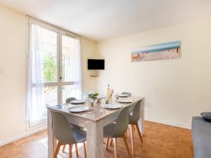 une salle à manger blanche avec une table et des chaises dans l'établissement Apartment Les Sables d'Or-8 by Interhome, au Grau-du-Roi