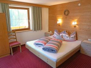 a bedroom with a bed with pillows and a window at Apartment Alpenhof-1 by Interhome in Sinsen