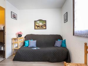 ein Wohnzimmer mit einem Sofa und blauen Kissen in der Unterkunft Apartment La Roche Blanche-7 by Interhome in Val Thorens