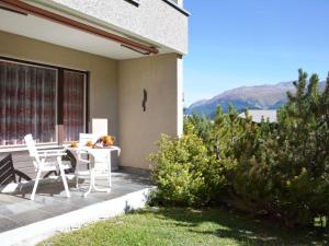 a patio with a table and chairs on the side of a house at Apartment Residenz Surlej 6 by Interhome in St. Moritz
