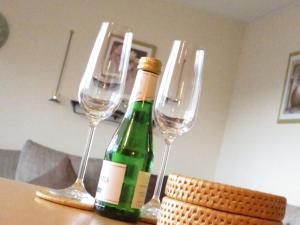 Apartment Panorama by Interhome في Berghofen: كأسين من النبيذ وزجاجة من النبيذ على طاولة