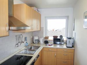 a kitchen with wooden cabinets and a sink and a window at Apartment Panorama by Interhome in Berghofen